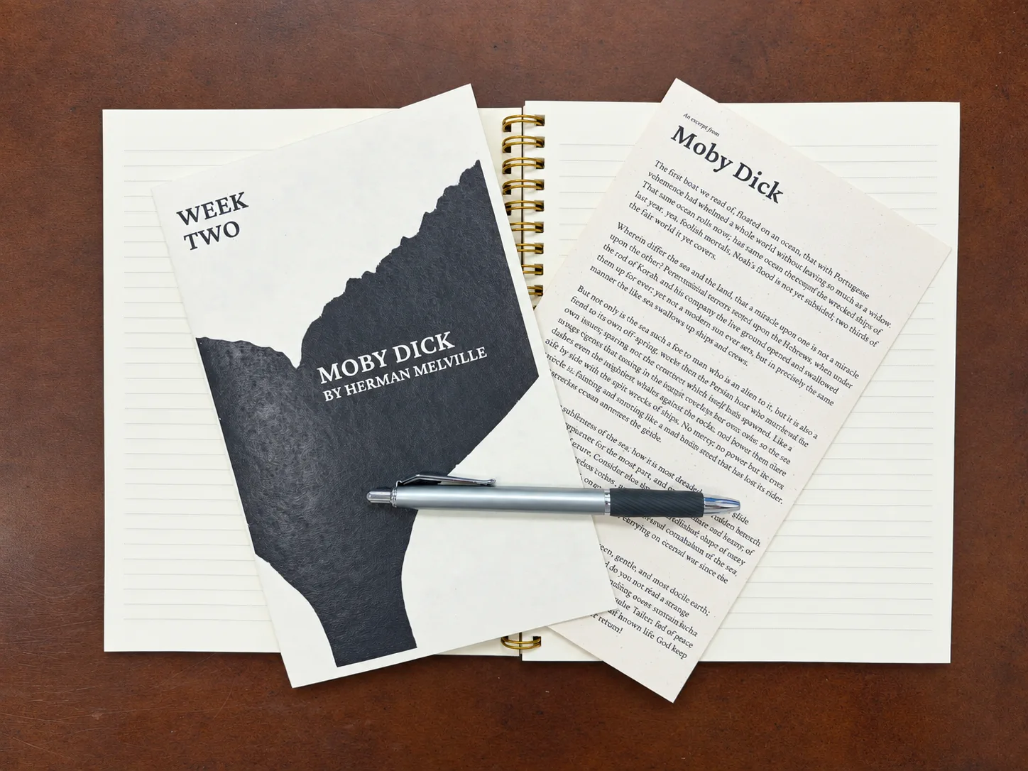 A Human by Hand Week Two Moby Dick packet with excerpt and pen on a notebook